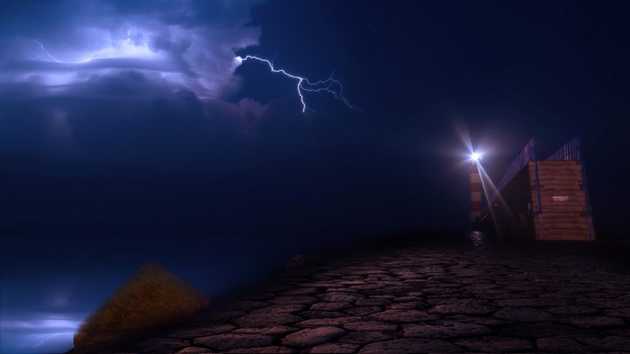 Lightning storm over Port la Nouvelle lighthouse at night