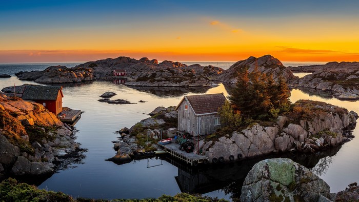 Houses on rocky islands in Norway at sunset