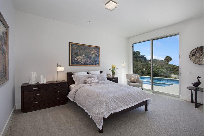 Bedroom with a view of a pool and hills