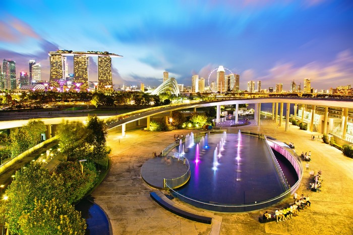 Marina Bay Sands and Singapore skyline at dusk with fountains