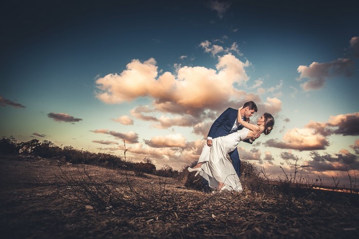 Couple dancing in a field at sunset