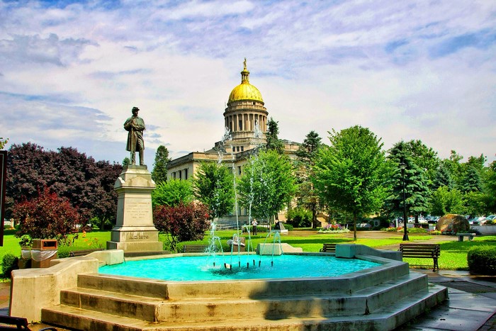 Soldier statue and fountain in front of a domed building
