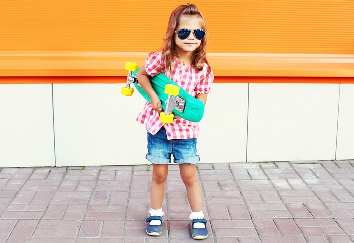 Girl with sunglasses holding a skateboard