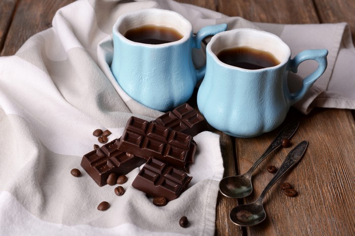 Two cups of coffee with chocolate and spoons