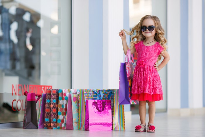 Little girl in pink dress with shopping bags