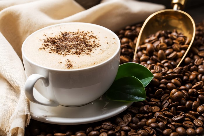 Coffee cup with coffee beans and scoop