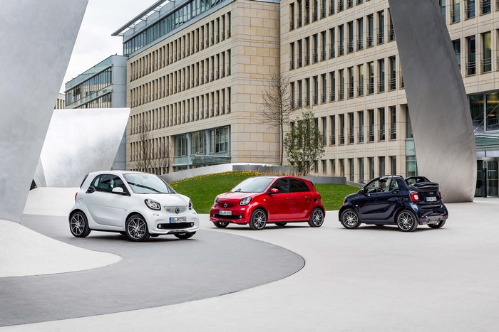 Smart Cars in front of a modern building