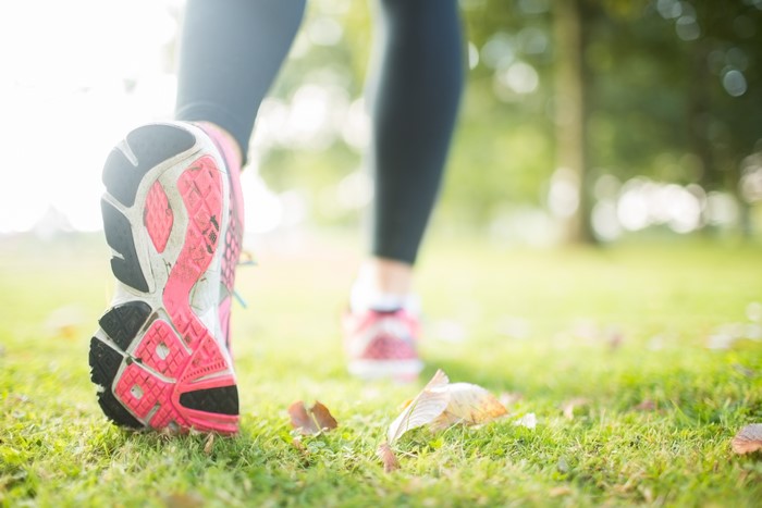 Close-up of athletic shoes running on grass