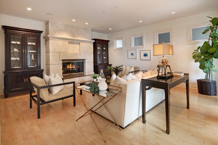 Living room with fireplace, armchair, and cabinets