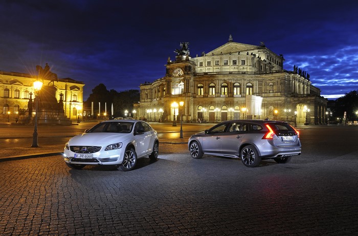 Two Volvo cars parked at night in front of a building