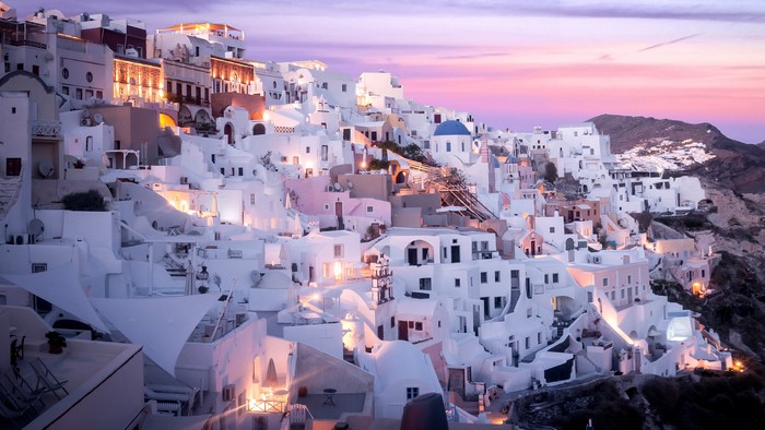 White houses on a cliffside in Santorini, Greece at sunset