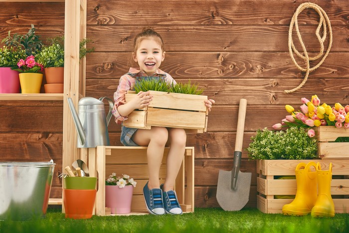 Little girl with gardening tools and tulips