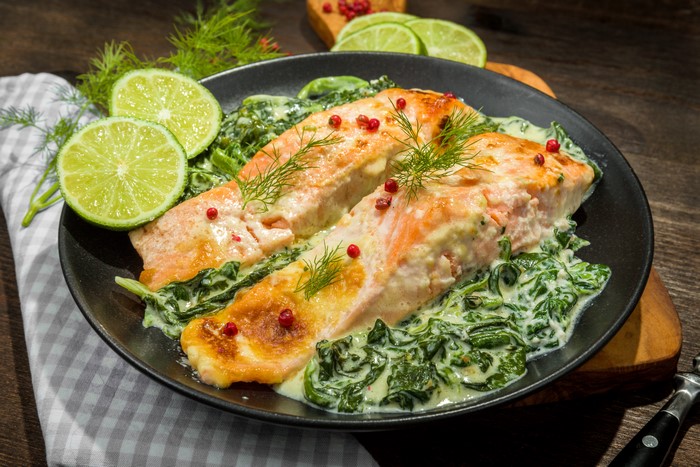 Salmon with spinach and lime on a plate