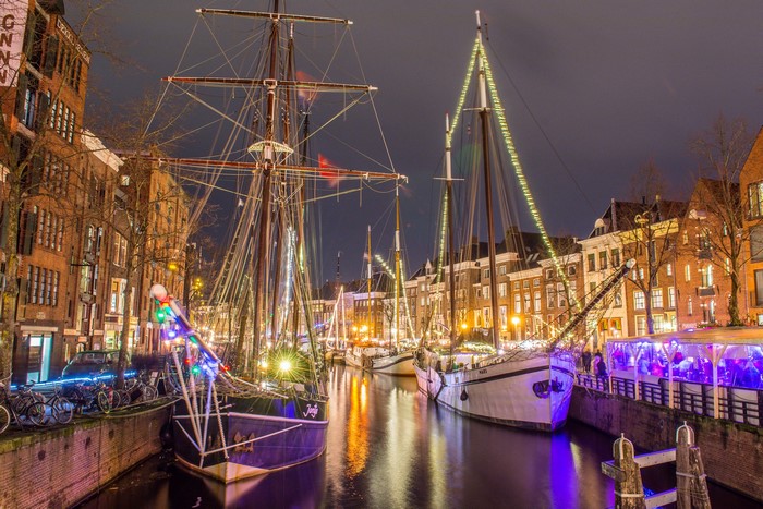 Ships decorated with lights on a canal in Groningen at night