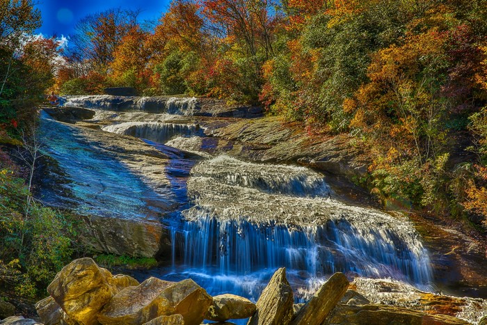 Waterfall cascading over rocks with autumn foliage