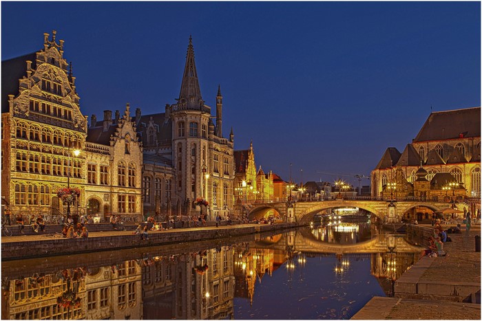 Ghent canal at night with historic buildings and bridge