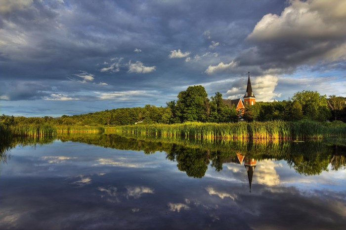 Church reflected in a lake with dramatic clouds