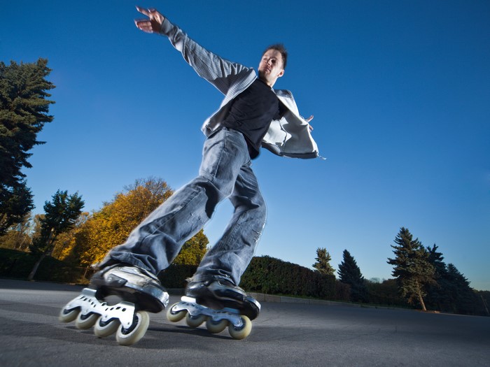 Man inline skating in jeans