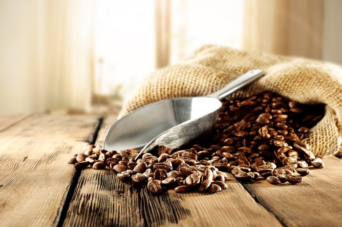 Coffee beans in a burlap sack with a scoop