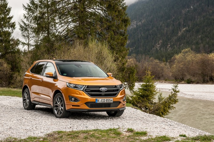 Orange 2015 Ford Edge Sport by a river