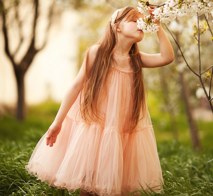 Girl smelling flowers in a dress