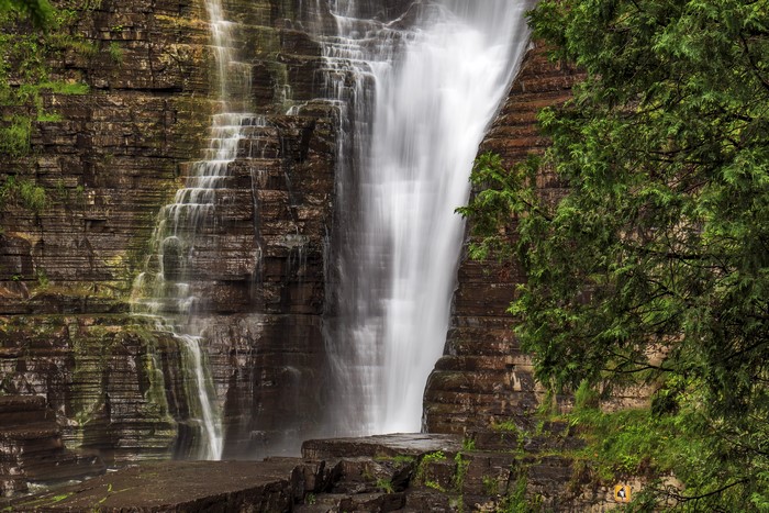 Waterfall cascading over a rocky cliff face in Quebec, Canada