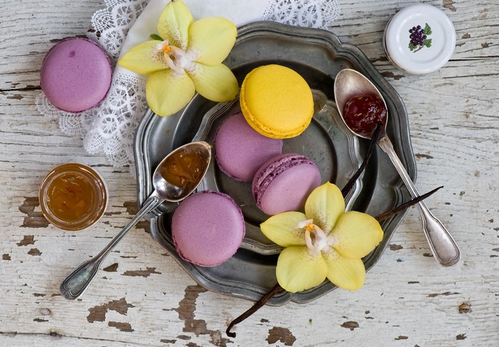 Macarons with jam and orchids on a tray