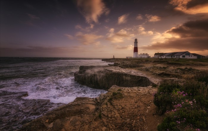 Portland Head Light Lighthouse on rocky coast at sunset