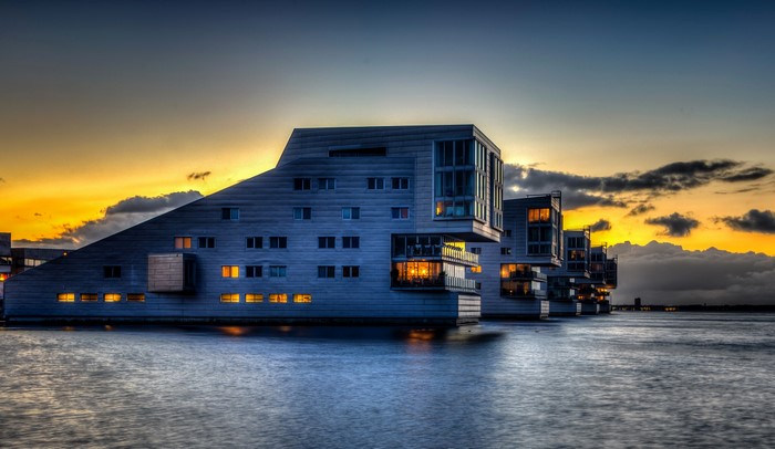 Modern houses on the water at sunset