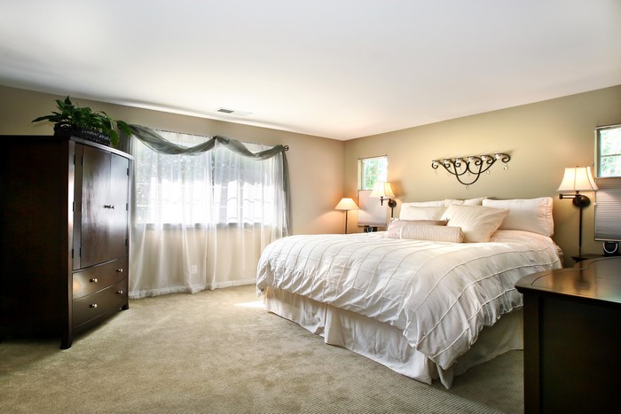 Bedroom with bed, dresser, and lamps
