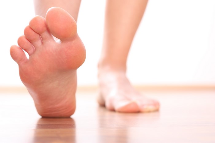 Bare feet walking on wooden floor