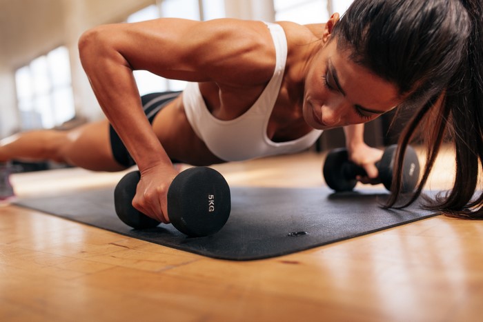 Woman doing push-ups with dumbbells