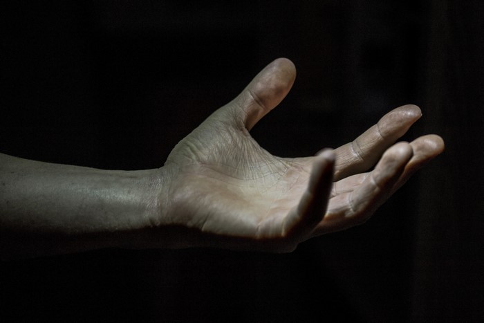 Closeup of a hand against a black background