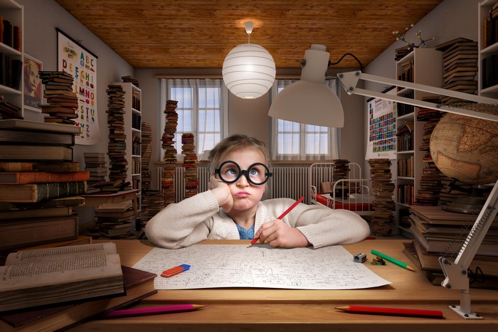 Little girl with glasses studying at a desk