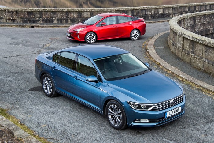 Blue Volkswagen Passat and Red Toyota Prius on Road