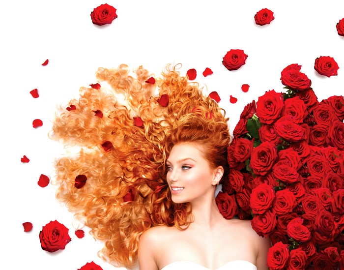 Redhead girl with red roses and petals