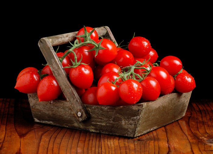 Basket of ripe tomatoes on a wooden table