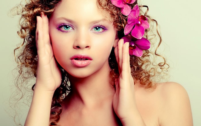 Girl with curly hair and orchids