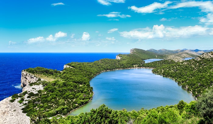 Savar, Croatia: Scenic lake and coastline under a blue sky