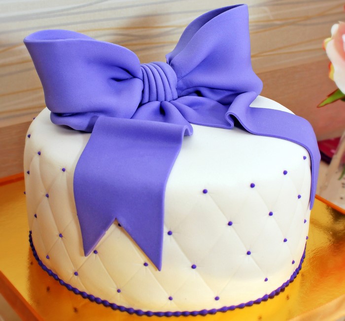 White cake with purple bow and dots