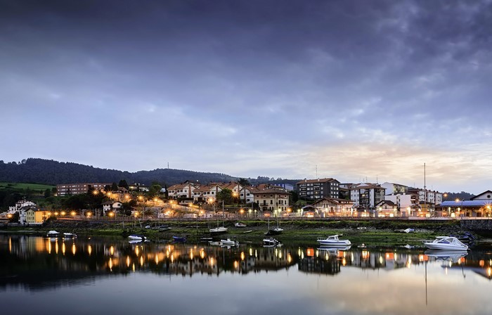 Town on a riverbank at dusk with boats
