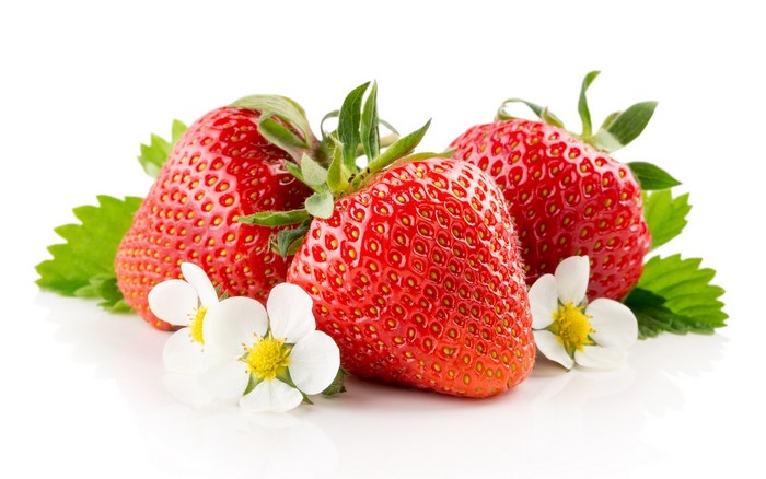 Three ripe strawberries with leaves and flowers