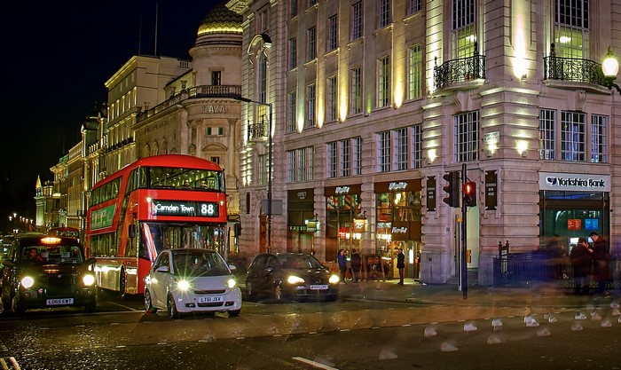 London street at night with red bus and cars