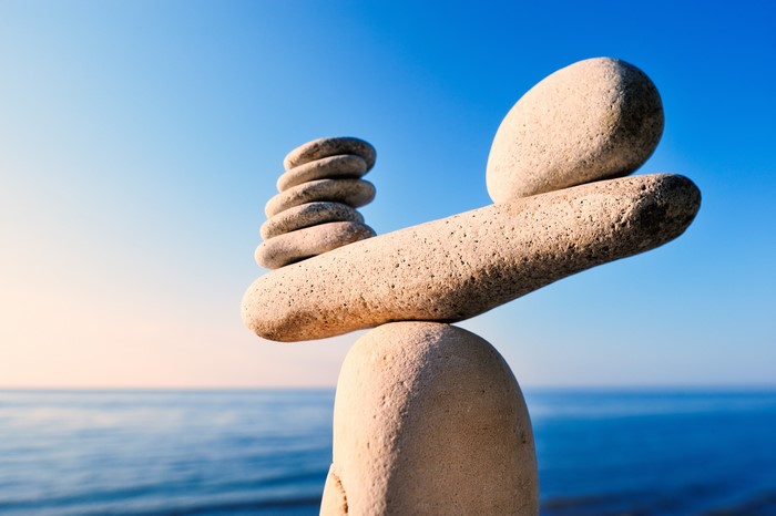 Stacked stones balanced on a larger stone by the sea