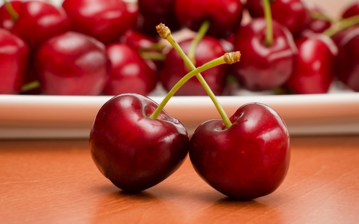 Two cherries with stems crossed