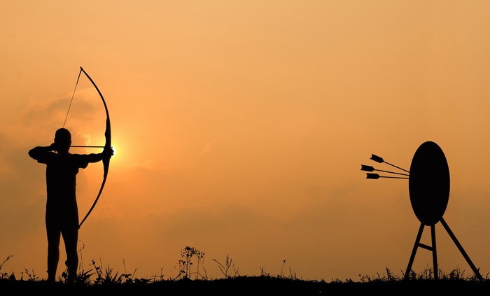 Silhouette of an archer shooting at a target