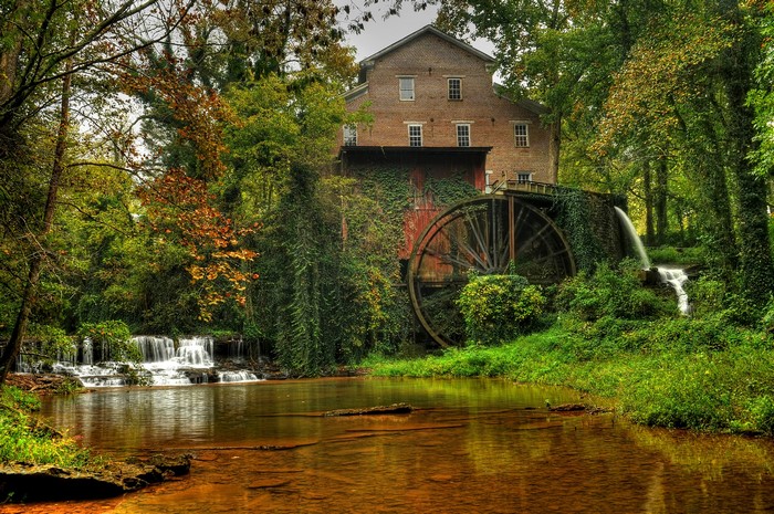 Watermill by a river with waterfalls