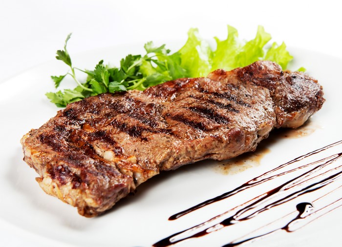 Grilled steak with lettuce and parsley