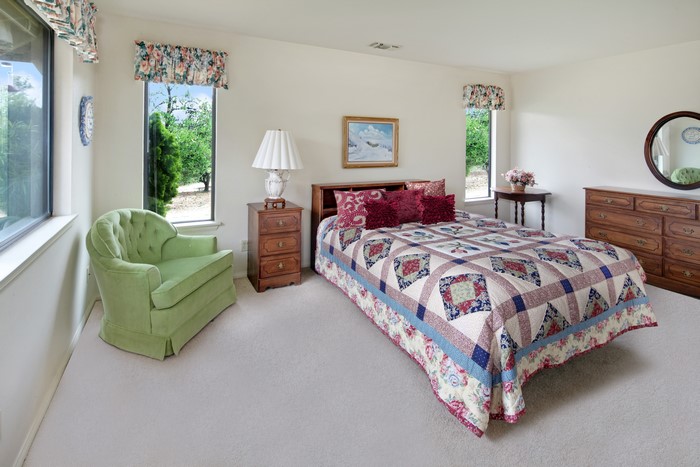 Bedroom with bed, armchair, and dresser