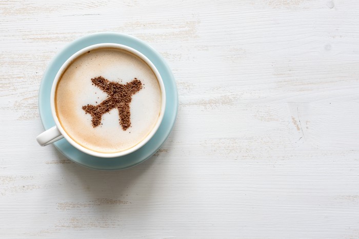 Coffee cup with airplane made of cocoa powder